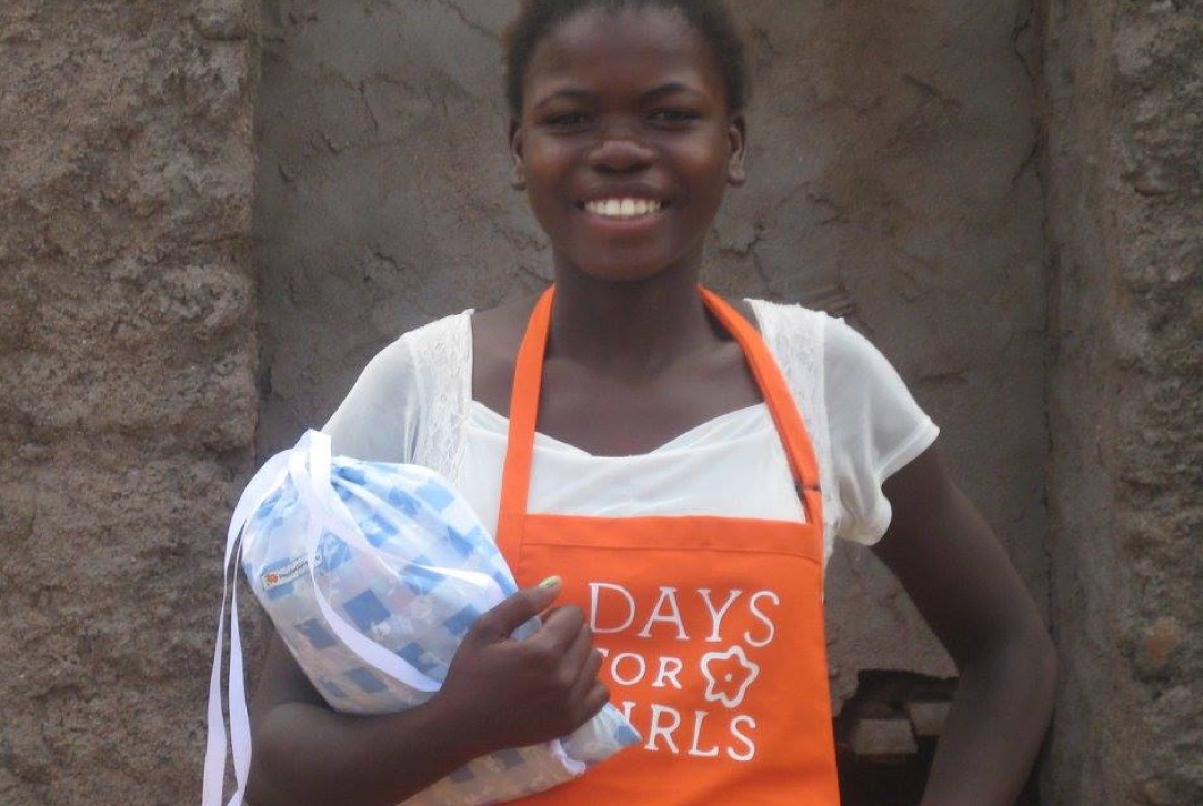 Girl wearing an orange Days for Girls apron