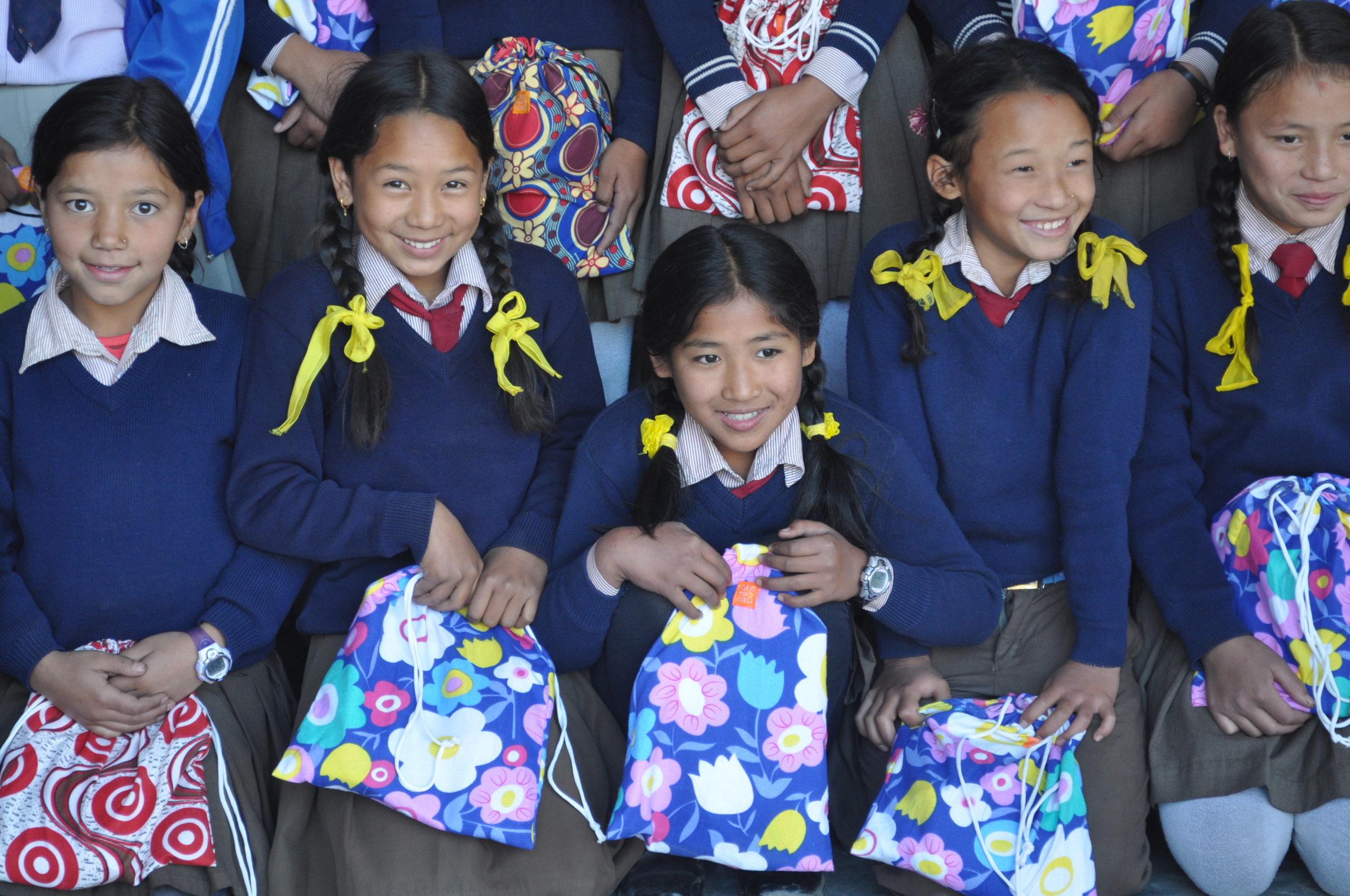 a group of girls holding their period kits