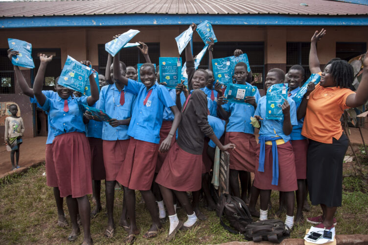 group of Ugandan girls in blue school uniforms with period kits