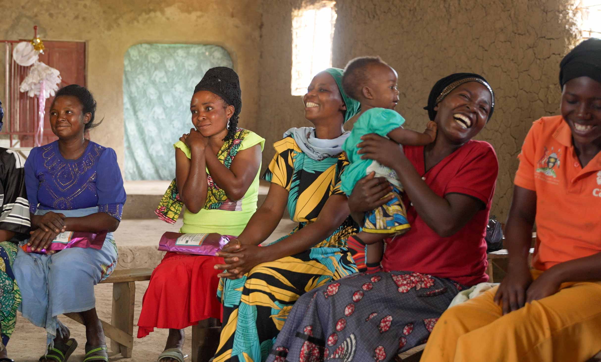 a group of women smiling and alughing while seated in a semi circle