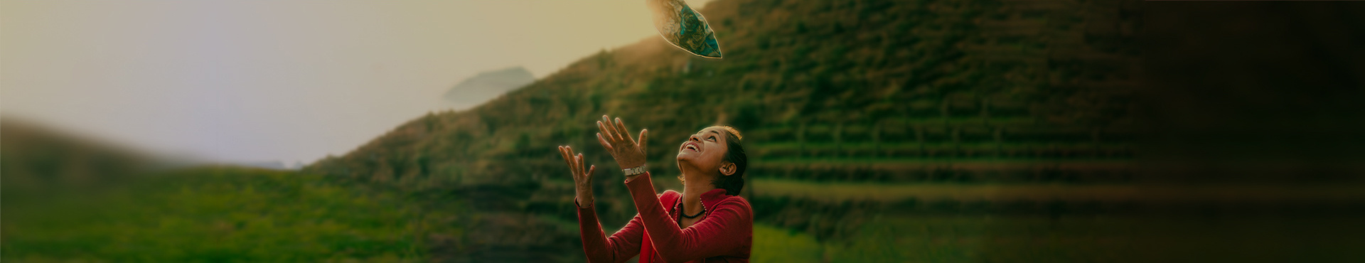 young woman looking up while catching water droplets